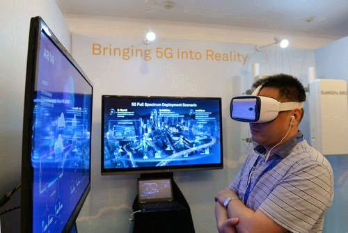嘉宾在峰会现场利用VR设备观看5G测试外场。